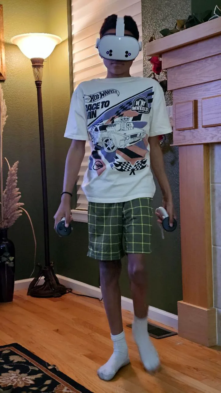 Jaden King wearing a VR headset and holding game controllers.